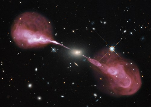 The radio galaxy Hercules A, seen in visible light (the galaxy at the center, background galaxies) and radio light, which shows the huge jets of matter streaming from the galaxy's central black hole. [Credit;  NASA, ESA, S. Baum & C. O'Dea (RIT), R. Perley and W. Cotton (NRAO/AUI/NSF),and the Hubble Heritage Team (STScI/AURA)]