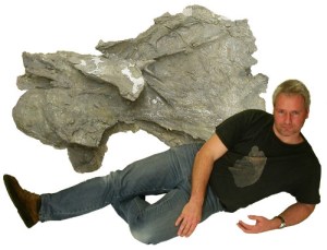 A piece of a Supersaurus vertebra, with paleontologist glamor for reference. While no other part of Supersaurus has been found yet, the shape of the bone identifies it as a sauropod, and the size of the fragment (that's not the whole vertebra!) marks it probably as the largest land animal that ever lived. [Credit: Sauropod Vertebra Picture of the Week/Mike Taylor]